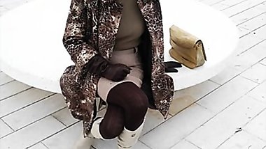 Crossed legs orgasm sitting on a bench in a park